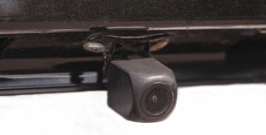 Close-up of a sensor camera on the back of a car, used for reverse parking, safety, and collision avoidance.